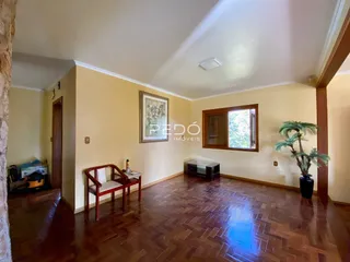 Uma sala de estar com piso de madeira e janela.