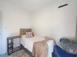 Quarto com cama e cabeceira em um ambiente claro.