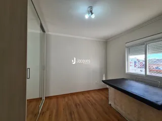 Ambiente interno com piso de madeira e janela na sala.