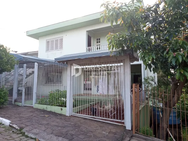 Fachada de uma casa em Lajeado, Brasil com cerca e portão de ferro.