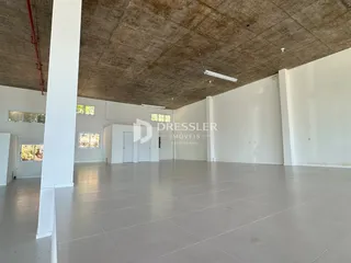 Vista interna de um espaço amplo com teto de concreto aparente.