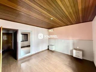 Sala de estar com piso de madeira e teto de madeira.