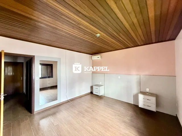 Sala de estar com piso de madeira e teto de madeira.
