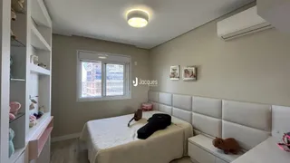 Quarto com cabeceira estofada e estantes brancas em um imóvel.