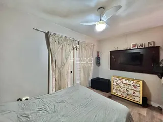 Quarto com cama e cortinas em um apartamento.