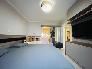 Quarto com cabeceira de madeira e cama grande em um imóvel no Brasil.