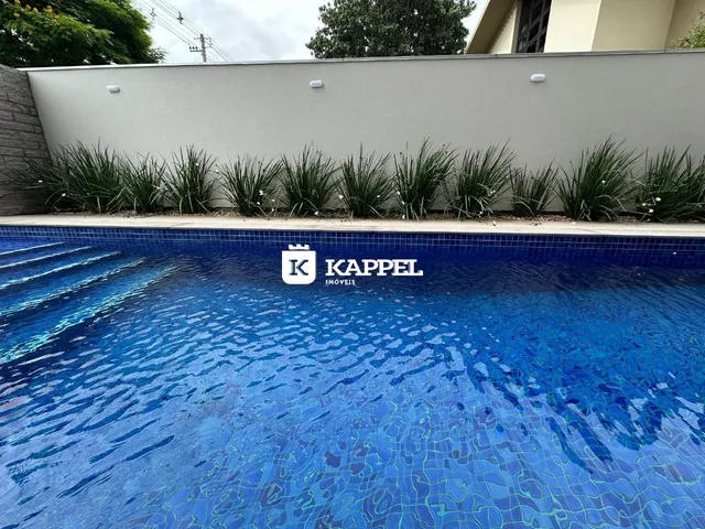 Piscina azul com paisagismo ao fundo em uma propriedade em Lajeado.