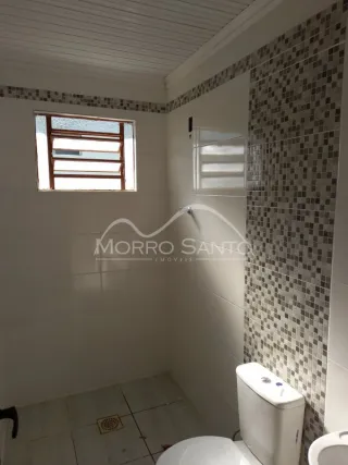 Foto de um banheiro interno com azulejos brancos e janela.