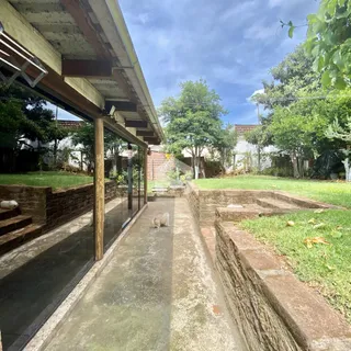 Vista externa de um pátio com jardim e muro de contenção em Lajeado.