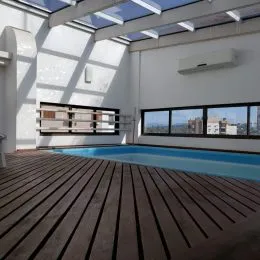 Foto da piscina externa com deck de madeira em uma propriedade.