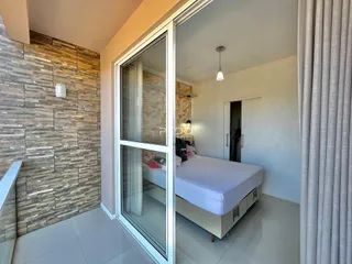 Quarto com cama e parede de tijolos aparentes em um imóvel no Brasil.