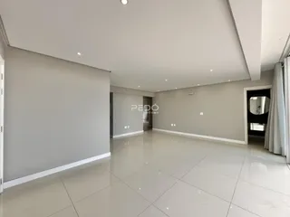 Ambiente interno de uma sala ampla com piso de cerâmica clara.
