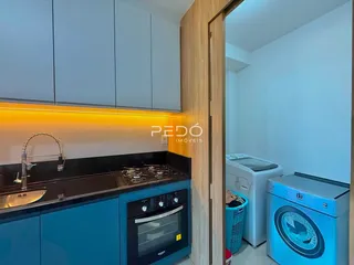 Cozinha moderna com armários azuis e bancadas escuras.