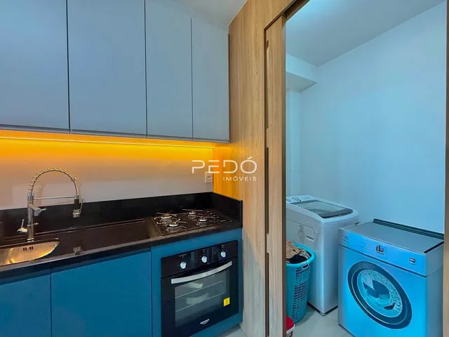 Cozinha moderna com armários azuis e bancadas escuras.