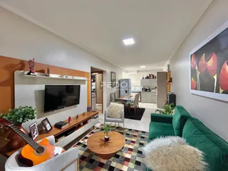 Sala de estar com sofá verde e piso de madeira na residência.
