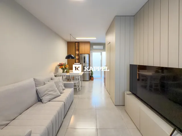 Esta é uma sala de estar com sofá branco e área de jantar em um imóvel.