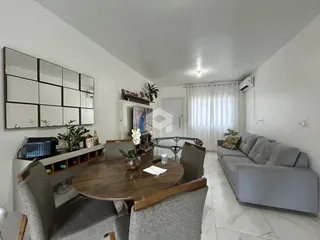 Sala de estar com mesa de jantar e sofá em um apartamento no Brasil.
