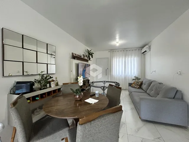 Sala de estar com mesa de jantar e sofá em um apartamento no Brasil.