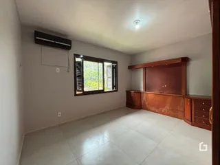 Ambiente interno de uma sala com piso de cerâmica e janela.