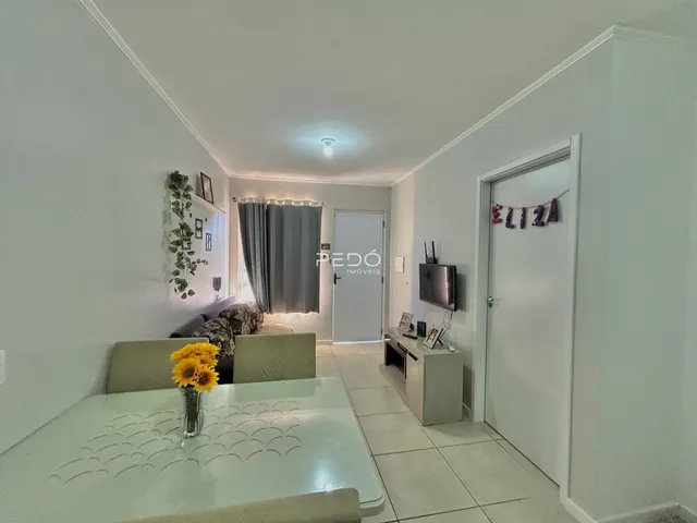 Sala de estar com sofá e mesa de jantar em ambiente claro.