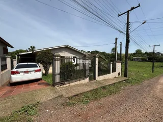Fachada de uma casa em Lajeado, Brasil, com cerca e terreno ao fundo.
