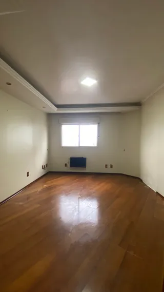 Vista interna de uma sala com piso de madeira polida.