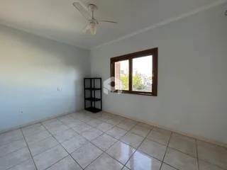 Ambiente interno de uma sala com piso de cerâmica clara.