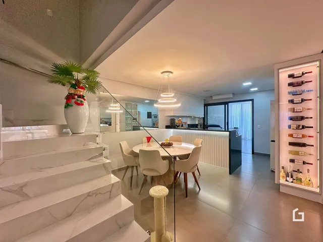 Ambiente moderno de sala de jantar com escadaria de mármore em um apartamento.
