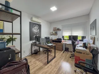 Foto de um escritório com piso de madeira e estantes na sala.