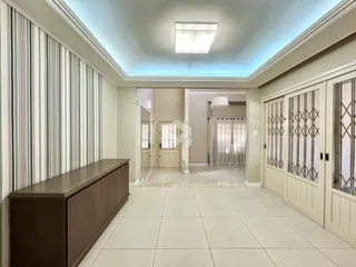 Hall de entrada com piso de cerâmica e molduras claras em uma residência.