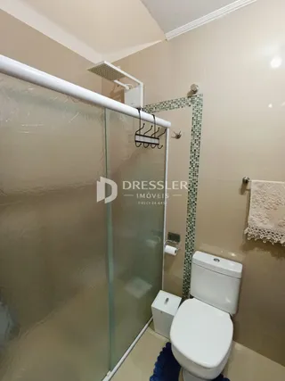 Interior de um banheiro com box de vidro e azulejos