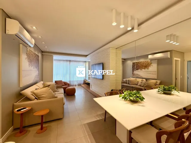 Sala de estar com sofá e mesa de jantar em um apartamento.