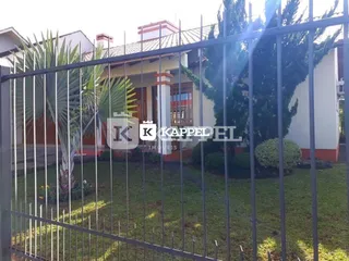 Vista externa de uma residência em Lajeado, Brasil, com cerca de metal e jardim.