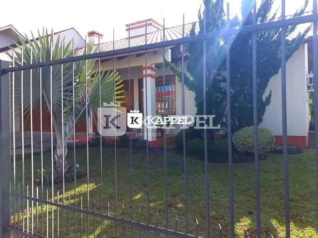 Vista externa de uma residência em Lajeado, Brasil, com cerca de metal e jardim.