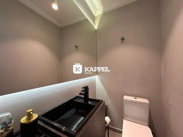 Foto de um banheiro com bancada escura e vaso sanitário branco.