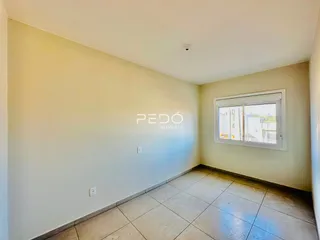 Interior de uma sala com piso de cerâmica e parede clara.