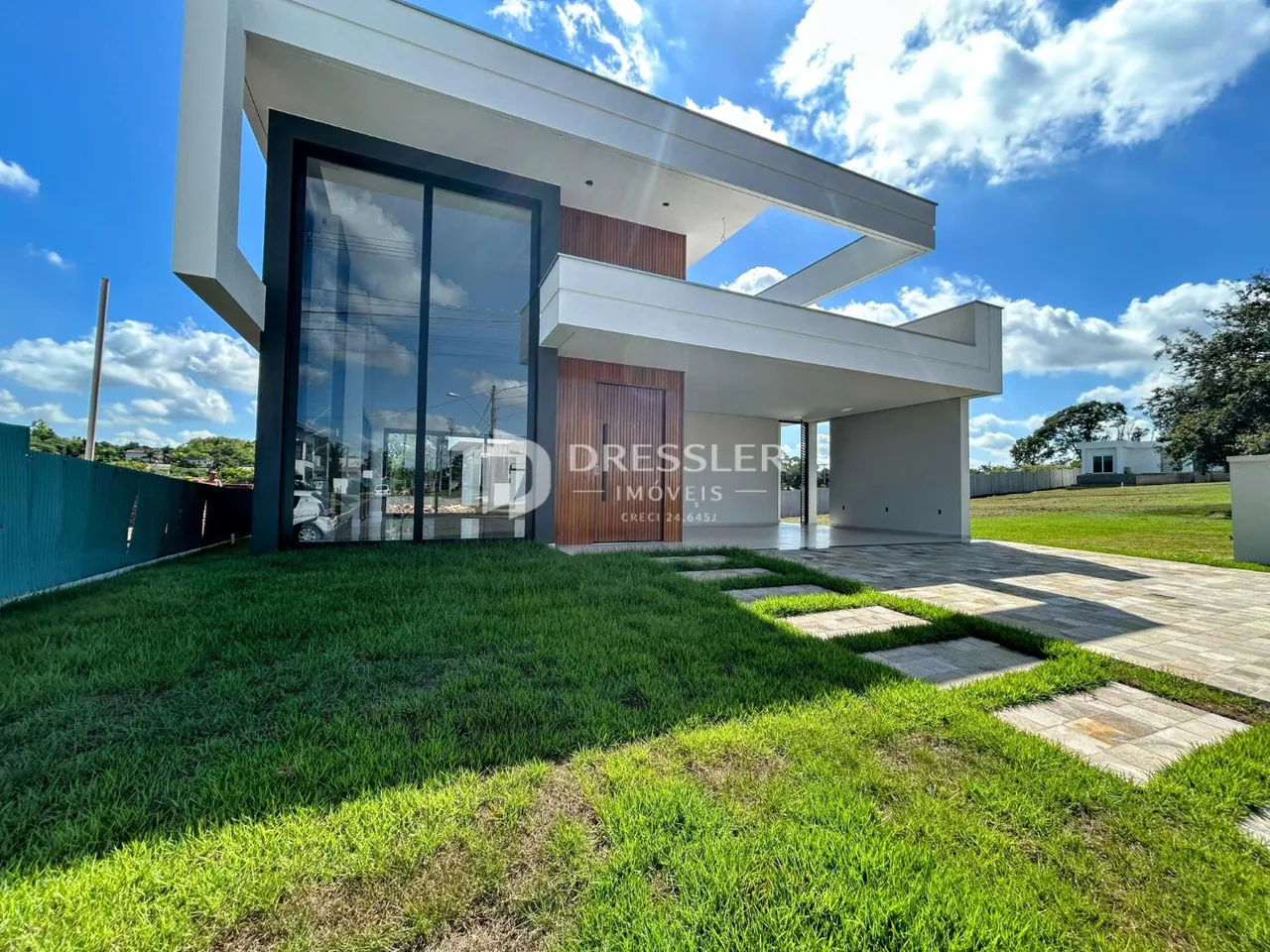 Fachada moderna de uma casa em Lajeado, Brasil, com jardim gramado.
