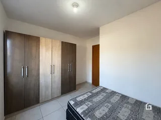 Quarto com armários em madeira e piso de cerâmica.