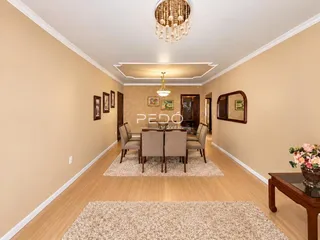 Hall de entrada com piso de madeira e mesa de jantar.