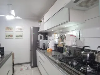 Cozinha moderna com armários brancos e bancadas de granito.