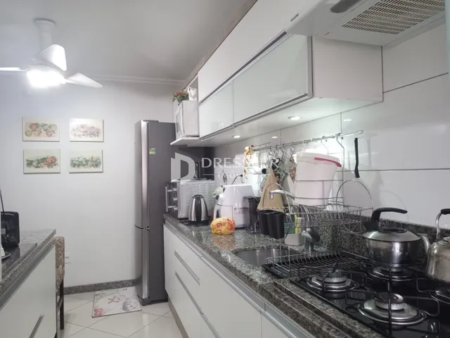 Cozinha moderna com armários brancos e bancadas de granito.
