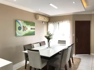 Sala de jantar com mesa e cadeiras em ambiente claro.