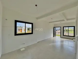 Interior de uma sala com grandes janelas em uma residência.