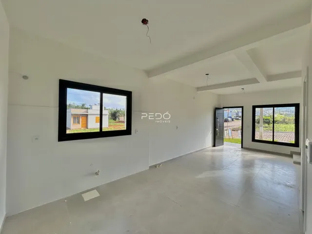 Interior de uma sala com grandes janelas em uma residência.
