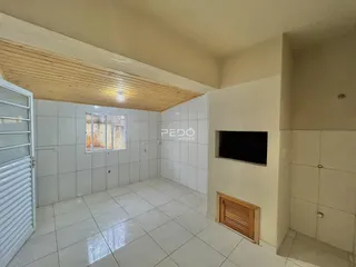 Interior de um ambiente com piso de cerâmica e teto de madeira clara.