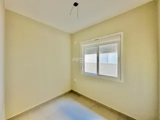 Ambiente interno de uma sala com paredes claras e piso de cerâmica.