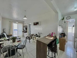 Sala de jantar e estar com piso de cerâmica clara e móveis de madeira.