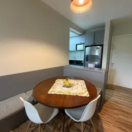 Mesa de madeira redonda com cadeiras em um ambiente interno.