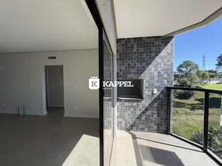 Sala de estar com vista para o exterior através de uma porta de vidro.