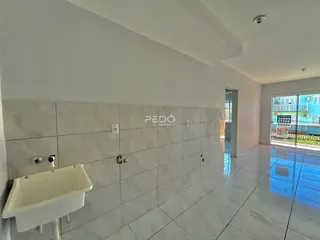 Banheiro com revestimento cerâmico branco e piso claro.